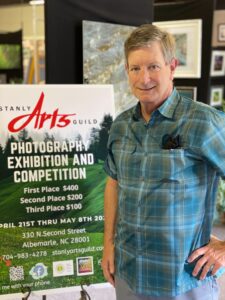 Judge David Whitesides standing with competition banner