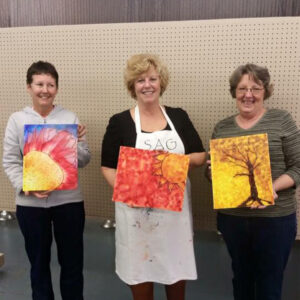 Workshop members showing their paintings.